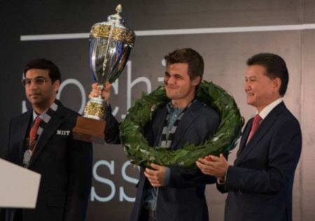 Norway's Magnus Carlsen shows his trophy at the award ceremony of the FIDE World Chess Championship Match  in Sochi, Russia, Tuesday, Nov. 25, 2014.   Magnus Carlsen won against India's former World Champion Vishwanathan Anand, left. At right is FIDE president Kirsan Ilyumzhinov. AP/PTI(AP11_26_2014_000006A)